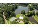 Aerial view of a pool, tennis court, and lake surrounded by lush trees at 12201 Lockhart Ln, Raleigh, NC 27614