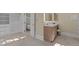 Bathroom featuring open closet space, a sink with cabinets, and an adjacent soaking tub at 12201 Lockhart Ln, Raleigh, NC 27614