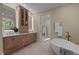 Elegant bathroom with double vanity, soaking tub, and neutral tile at 12201 Lockhart Ln, Raleigh, NC 27614