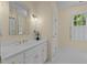 Bathroom features a single vanity with gold fixtures, large mirror and a bright window at 12201 Lockhart Ln, Raleigh, NC 27614