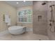 Modern bathroom featuring a soaking tub, stand-up shower, and many windows for natural light at 12201 Lockhart Ln, Raleigh, NC 27614