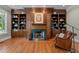 Cozy living room features custom bookshelves, a fireplace with green marble, and a leather chair at 12201 Lockhart Ln, Raleigh, NC 27614