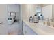Bright bathroom featuring double sinks, quartz countertops, white cabinets, and access to the bedroom at 124 Seagraves Creek Ln, Holly Springs, NC 27540