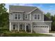 Charming two-story home with a welcoming front porch and attached two-car garage at 124 Seagraves Creek Ln, Holly Springs, NC 27540