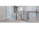 Bright upstairs hallway features a staircase, modern railings, carpet, and access to multiple rooms at 124 Seagraves Creek Ln, Holly Springs, NC 27540
