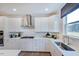 Modern kitchen with white cabinets, stainless steel appliances, and decorative backsplash, perfect for cooking at 124 Seagraves Creek Ln, Holly Springs, NC 27540