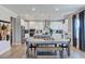 Open-concept kitchen and dining area featuring modern appliances, white cabinets, and stylish pendant lighting at 124 Seagraves Creek Ln, Holly Springs, NC 27540