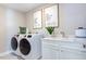 Well-equipped laundry room with modern washer and dryer, a sink, and stylish decor at 124 Seagraves Creek Ln, Holly Springs, NC 27540