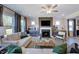 Spacious living room with fireplace, TV, comfortable seating, and large windows offering outdoor views at 124 Seagraves Creek Ln, Holly Springs, NC 27540