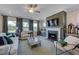 Cozy living room featuring a fireplace, large windows with natural light, and stylish furnishings at 124 Seagraves Creek Ln, Holly Springs, NC 27540