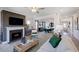 Inviting living room showcasing fireplace, modern furnishings, and an open layout to the dining area at 124 Seagraves Creek Ln, Holly Springs, NC 27540