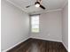 Cozy bedroom with a ceiling fan, neutral walls and dark hardwood floors at 12421 Angel Vale Pl, Durham, NC 27703