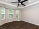 Well-lit bedroom features a ceiling fan, recessed lights, and multiple windows for natural light at 12421 Angel Vale Pl, Durham, NC 27703