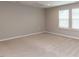 Bright bedroom with neutral carpet, ample natural light streaming through the window, and a clean, minimalist design at 12421 Angel Vale Pl, Durham, NC 27703