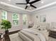 Bright bedroom showcasing a large window, ceiling fan, and comfortable furnishings in a staged setting at 12421 Angel Vale Pl, Durham, NC 27703