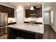 Modern kitchen with granite counters, stainless appliances, large island, and dark wood cabinets at 12421 Angel Vale Pl, Durham, NC 27703