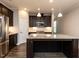 Modern kitchen with granite counters, stainless appliances, large island, and dark wood cabinets at 12421 Angel Vale Pl, Durham, NC 27703