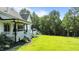 Expansive backyard view featuring a well-maintained lawn, trees, and deck with an outdoor seating area at 125 Attena Way, Zebulon, NC 27597
