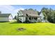 Picturesque backyard with lush green grass, landscaping, and the home's back exterior including deck and patio at 125 Attena Way, Zebulon, NC 27597