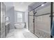 Bright bathroom with a freestanding tub, walk-in shower with stone accents, and gray cabinets at 125 Attena Way, Zebulon, NC 27597