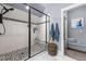 Modern bathroom highlighting a walk-in shower with pebble accents, gray cabinets, and neutral colors at 125 Attena Way, Zebulon, NC 27597