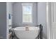 Bright bathroom featuring a freestanding tub, modern fixtures, and neutral walls at 125 Attena Way, Zebulon, NC 27597