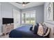 Cozy bedroom with a plush bed, neutral decor, a view of the outdoors, and a ceiling fan for comfort at 125 Attena Way, Zebulon, NC 27597