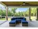 Inviting covered patio with blue cushioned seating and a ceiling fan overlooking the serene backyard at 125 Attena Way, Zebulon, NC 27597