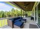 Relaxing covered patio featuring comfortable seating, ceiling fans, and wooded views for outdoor enjoyment at 125 Attena Way, Zebulon, NC 27597