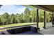 Scenic view from the covered patio with comfortable seating and a tranquil backyard backdrop at 125 Attena Way, Zebulon, NC 27597