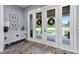 Inviting entryway with stylish console table, wood-look flooring, and charming wreaths on the glass front doors at 125 Attena Way, Zebulon, NC 27597