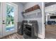 A modern laundry room features a side-by-side washer and dryer and access to the backyard at 125 Attena Way, Zebulon, NC 27597