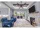 Open living room featuring fireplace, a sliding glass door and tray ceiling with rustic wood beams at 125 Attena Way, Zebulon, NC 27597