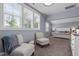 Light-filled main bedroom featuring two chairs, ample windows, and a neutral color palette with carpeted floor at 125 Attena Way, Zebulon, NC 27597