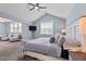 Comfortable main bedroom showcasing a ceiling fan, TV, ample windows, neutral walls and comfortable furniture at 125 Attena Way, Zebulon, NC 27597