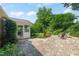 Large backyard with stone patio, mature trees, green grass, and sunroom at 1311 Norton St, Durham, NC 27701