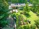 A sprawling backyard features a stone patio, garden, and large grassy area, all surrounded by mature trees and lush greenery at 1311 Norton St, Durham, NC 27701