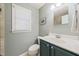 Cozy bathroom with a modern vanity, grey walls, a window, and tile accents at 1311 Norton St, Durham, NC 27701