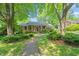 A charming brick home with a covered front porch and manicured lawn features a stone walkway leading to the entrance at 1311 Norton St, Durham, NC 27701