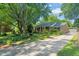A charming single-story brick home featuring a well-manicured front lawn, a driveway, and a classic American flag at 1311 Norton St, Durham, NC 27701