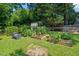 Backyard featuring raised garden beds, lush green grass, and shaded area at 1311 Norton St, Durham, NC 27701