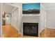 Hallway featuring hardwood floors, access to multiple rooms, and a fireplace with mounted television at 1311 Norton St, Durham, NC 27701
