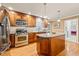 Well-equipped kitchen featuring stainless appliances, island with granite countertops, and wood cabinetry at 1311 Norton St, Durham, NC 27701