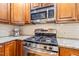 Close up of stainless steel microwave and gas stove with granite countertops and subway tile backsplash at 1311 Norton St, Durham, NC 27701