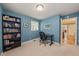 Study with a large bookshelf, black desk and chair, and a serene blue wall color at 1311 Norton St, Durham, NC 27701