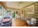 Bright sunroom featuring brick accent wall, wood floors, ceiling fan, and lots of natural light at 1311 Norton St, Durham, NC 27701