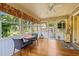 Bright sunroom with hardwood floors, ceiling fan, and many windows for natural light and backyard view at 1311 Norton St, Durham, NC 27701