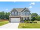 Beautiful two-story home featuring a stone and gray facade with a well-manicured lawn at 1321 White Spruce Dr, Willow Springs, NC 27592