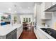 Bright kitchen with farmhouse sink, island seating, stainless appliances, and adjacent living space at 1321 White Spruce Dr, Willow Springs, NC 27592