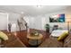 Open living room featuring hardwood floors, a leather couch, and staircase to the upper level at 1321 White Spruce Dr, Willow Springs, NC 27592